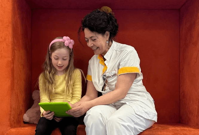 A child and a hospital professional using Hospital Hero together